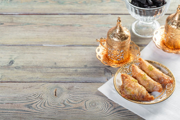 Traditional arabic dessert baklava with cashew, walnuts and cardamom with an eucalyptus branch on a wooden table