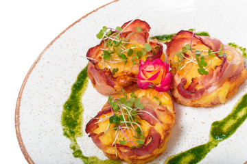 plate of bacon wrapped scallops in neat rows on a light colored plate