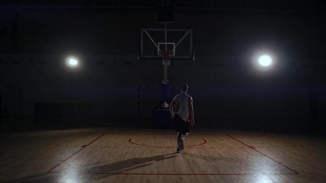 Behind shot of basketball player shooting hoops.