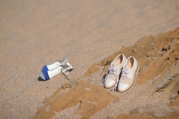 Fototapeta na wymiar two pairs of shoes in the sand