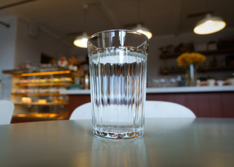 a glass of water is on the table in a trendy coffee shop