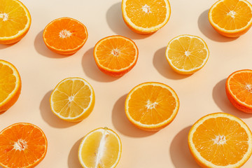 Composition of citrus fruits cut in half on a light yellow background. Top view.
