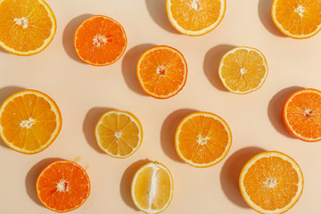 Composition of citrus fruits cut in half on a light yellow background. Top view.