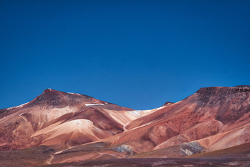Fototapeta na wymiar Dry arid mountains with red soil in the desert