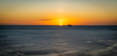 Naklejka na ściany i meble Sunset backgound with sailing cruise ship.