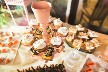 Delicious sweets on wedding candy buffet with desserts, cupcakes
