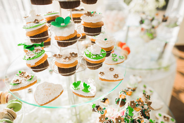 Delicious and tasty dessert table with cupcakes shots at reception closeup