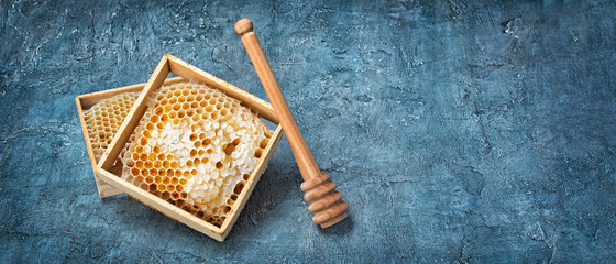 Natural product honeycomb as organic ingredient for healthy nutrition with wooden honey stick