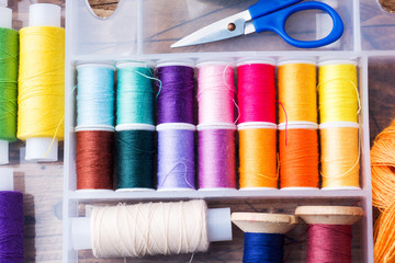 Sewing tool for needlework. colored threads, centimeter and buttons with a pair of scissors on the table. close-up.