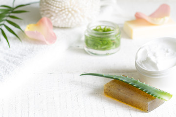 Natural cosmetics for skin care with petals rose and aloe vera on white planks
