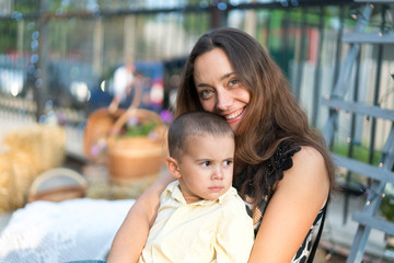 Mom holds a child in her arms. A happy family. Young mother holding her baby in her arms and stroked my mother's child litso. Portret mother and little son.