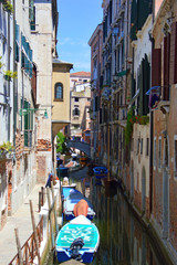 Venetian canal detail with small boat in summer