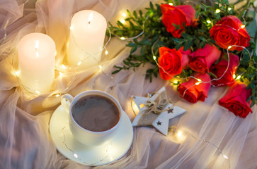 Composition: red roses with boxwood, garlands, candles, star and cup coffee (tea)