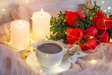 Composition: red roses with boxwood, garlands, candles, star and cup coffee (tea)