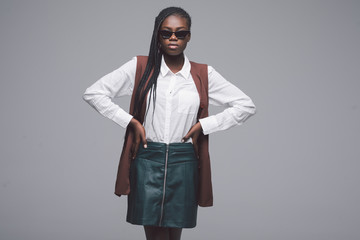 Stylish fashion young african woman in sunglasses gainst dark background.