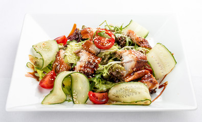 Asian salad with eel and cucumber. On white background