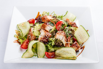 Asian salad with eel and cucumber. On white background