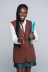 Beautiful young Afro American business woman in formal wear is holding a folder, looking at camera...