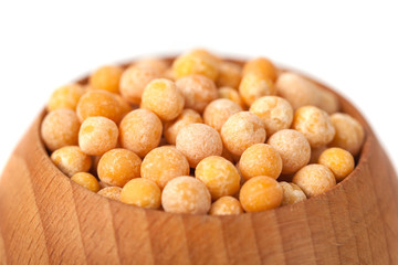 Dry yellow peas on wooden bowl isolated on white background