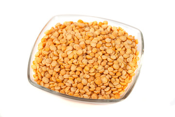 Seeds of peas on glass bowl on white background