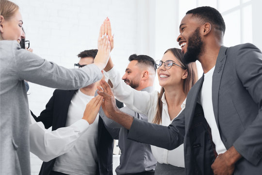 Team achievement, diverse business people giving high five