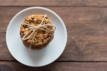 delicious, crispy oatmeal cookies with chocolate on wooden background