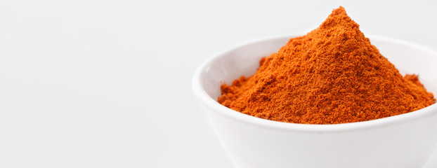 Pile of paprika powder in white bowl