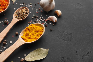 Turmeric, bay leaves and garlic on dark table