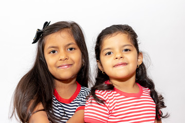 Cute sisters with striped dresses laughing