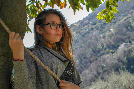 Jeune fille blonde se tenant &agrave; une corde sous un arbre oranger bigaradier en Provence &agrave; Bar sur Loup capital de l'oranger