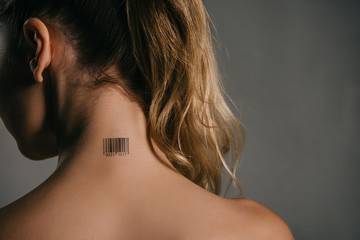 back view of woman with barcode on neck on grey background