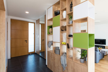 Custom made colorful wooden shelves in the hall of modern house