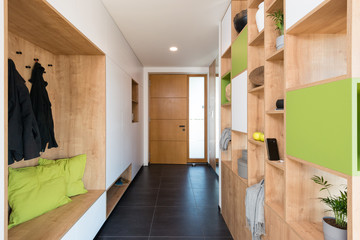 Custom made colorful wooden shelves in the hall of modern house