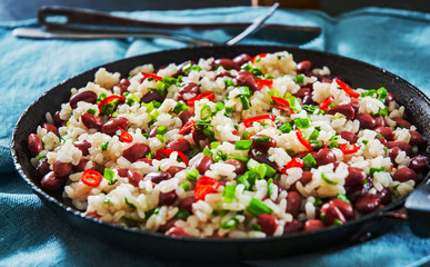 rice with red beans and vegetables in a frying pan