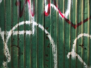close up background of rusted galvanized iron plate in green color with white and red painting