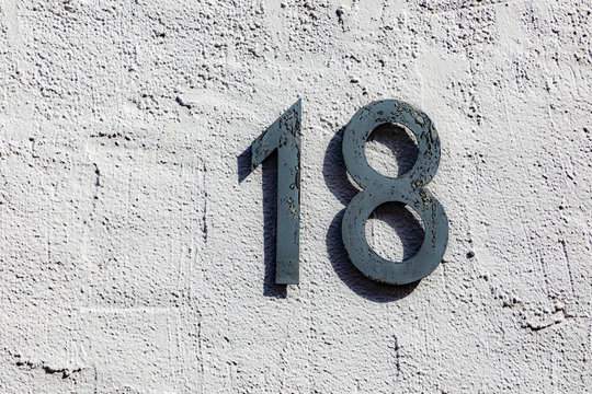 house number eighteen at a rough wall