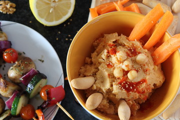High Angle View of Vegetarian Mediterranean Meal of Grilled Vegetables and Hummus Dip Spread Out on table.