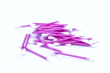 Pink colored cotton coated ear buds or Q-tips isolated on white.