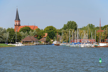 Fototapeta premium Harbor and church in Wustrow. Wustrow is a municipality at Baltic Sea coast in Mecklenburg-Vorpommern, Fischland, Germany