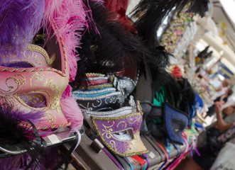 Extreme close up of some colorful carnival masks at a banquet for tourists, at the most famous market in the city of Verona.