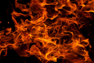 Fire flames on Abstract art black background, Burning red hot sparks rise from large, Fiery orange glowing