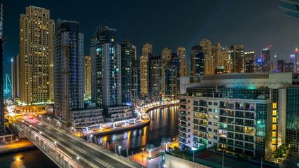 Fototapeta na wymiar Dubai Marina at night timelapse with light trails of boats on the water and cars, Dubai, UAE