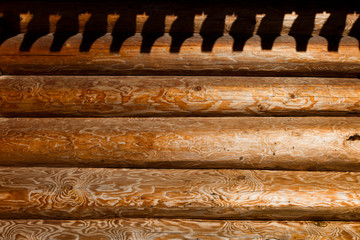 The shadow from the traditional old Russian roof on the logs of the hut