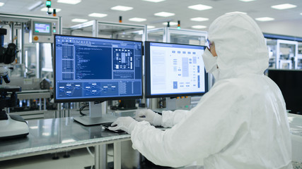 Shot of a Scientists in Sterile Suits Working with Computers, Analyzing Data form Modern Industrial...