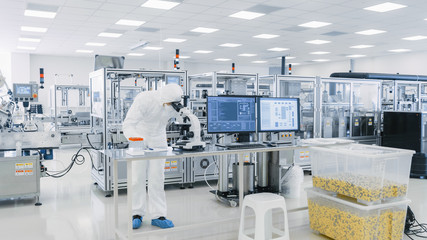 Shot of Sterile Pharmaceutical Manufacturing Laboratory where Scientists in Protective Coverall's Do Research, Quality Control and Work on the Discovery of new Medicine.  - obrazy, fototapety, plakaty