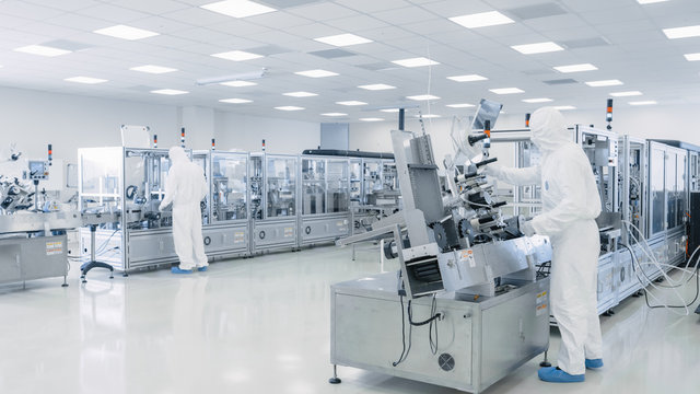 Sterile High Precision Manufacturing Laboratory where Scientists in Protective Coverall's Turn on Machninery, Use Computers and Microscopes, doing Pharmaceutics and Semiconductor Research.