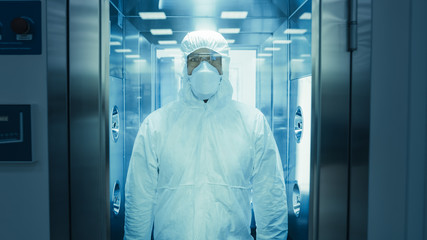 Scientist / Virologist / Factory Worker in Coverall Suit Disinfects Himself in Decontamination...