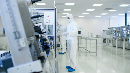 Sterile High Precision Manufacturing Laboratory where Scientists in Protective Coverall's Turn on...