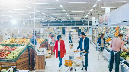 Foto op Plexiglas At the Supermarket: Happy Family of Three, Holding Hands, Walks Through Fresh Produce Section of the Store. Father, Mother and Daughter Having Fun Time Shopping. High Angle Panoramic Shot. © Gorodenkoff