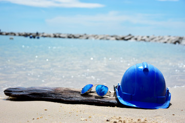 Obraz premium Safety Helmet and the sun glasses on the seascape background